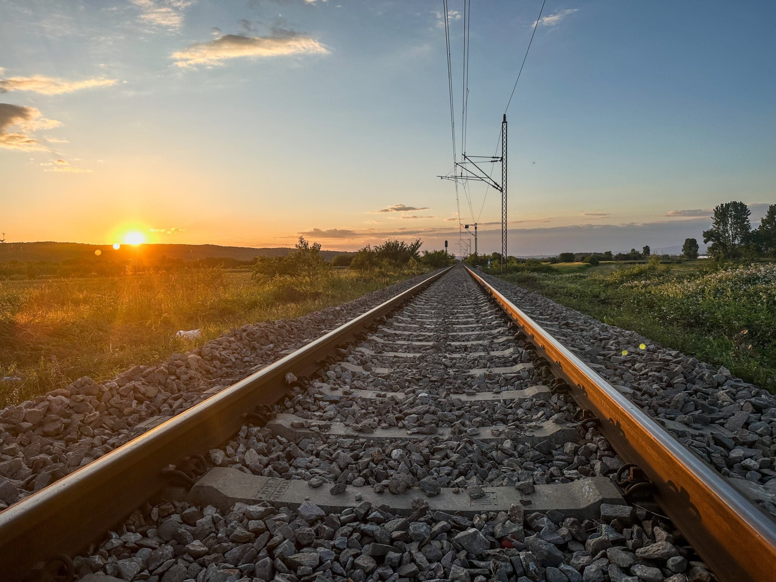Railway tracks at sunset representing new transport investment and regional connectivity across the Oxford to Cambridge corridor.