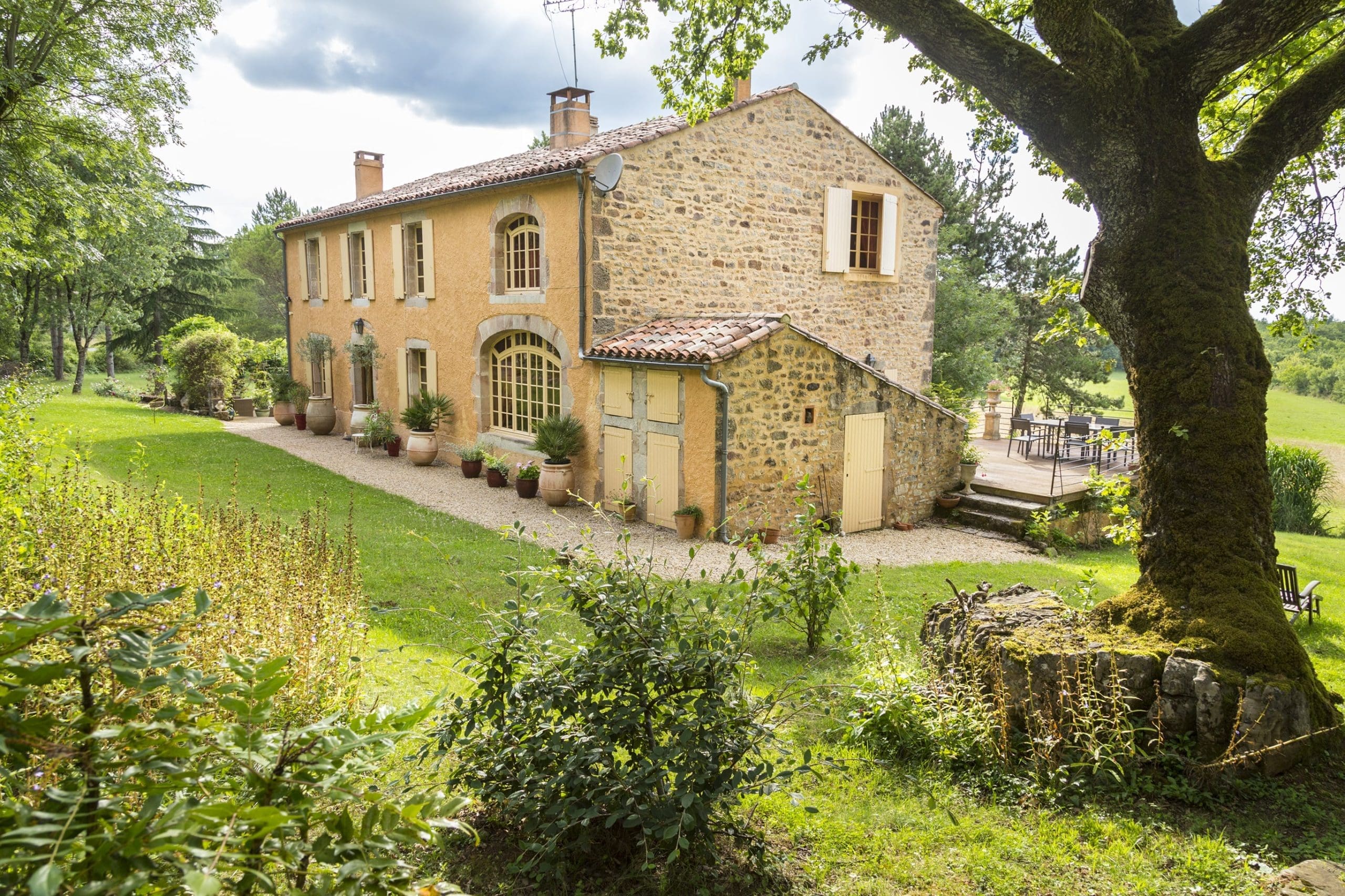 Traditional French stone house with shutters and a garden, representing property commonly owned through an SCI.
