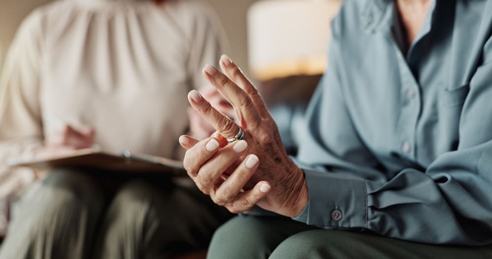 “Close-up of a supportive conversation, showing hands of a legal advisor and a client in a confidential setting.”