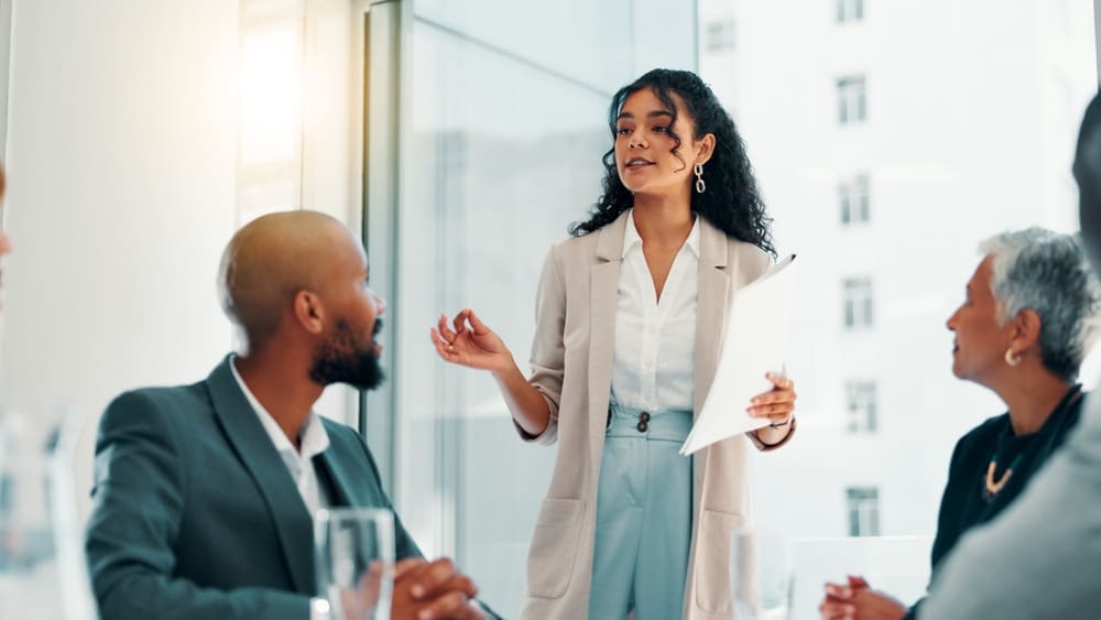 A diverse group of professionals discussing in a meeting, emphasizing collaboration in handling workplace complaints and investigations.
