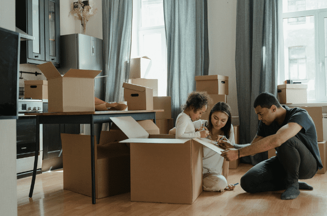 a family buying or selling their home sit amongst boxes